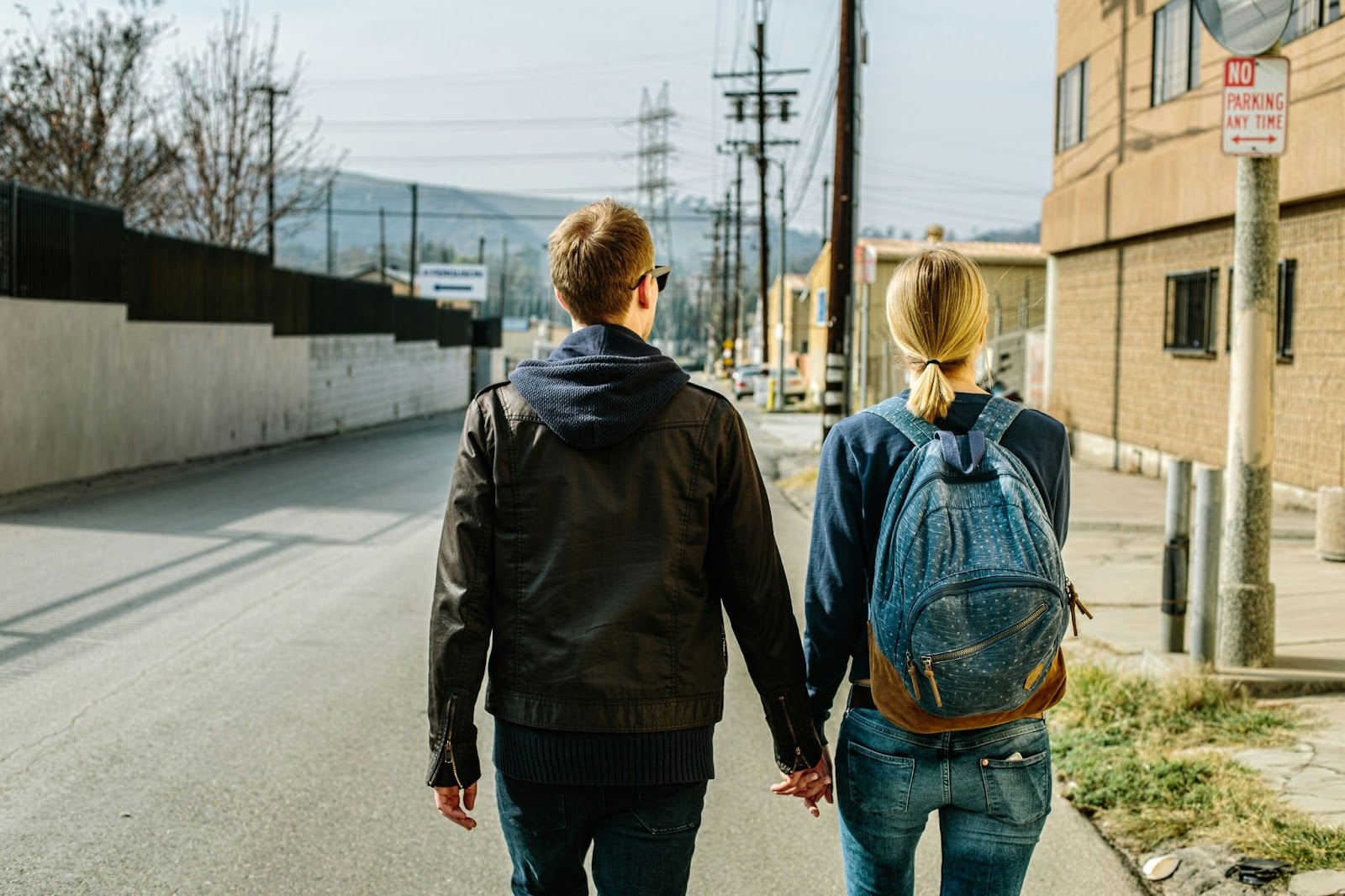 a couple holds hands while on a walk during the day